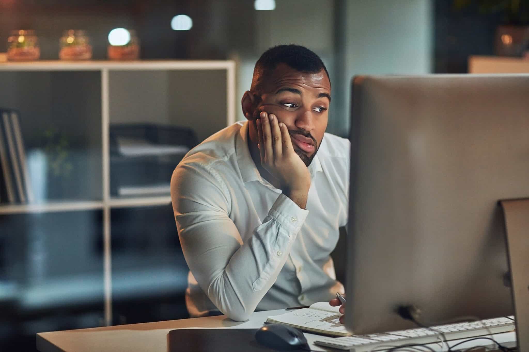 Man looking bored at computer, reflecting on how long a whiteboard or explainer video should be.